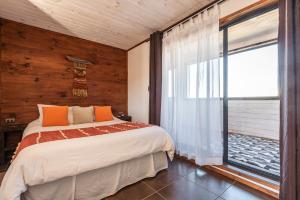 una camera da letto con un letto e una grande finestra di Pichilemu Apart Hotel a Pichilemu