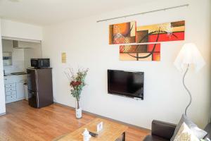 a living room with a flat screen tv on a wall at Bios Hall / Vacation STAY 2181 in Sapporo