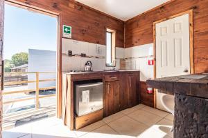 a kitchen with wooden walls and a large window at Pichilemu Apart Hotel in Pichilemu