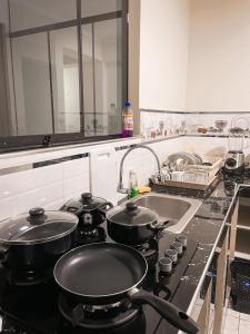 a kitchen with two pots on a stove with a sink at Apart La Merced in Caraz