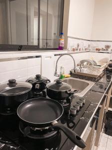 uma cozinha com duas panelas num fogão com um lavatório em Apart La Merced em Caraz