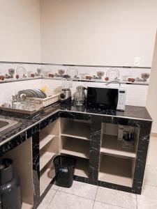 a kitchen with a black counter top with a microwave at Apart La Merced in Caraz