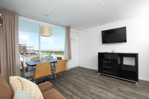 a living room with a dining room table and a television at Olympic Island Beach Resort in Wildwood Crest
