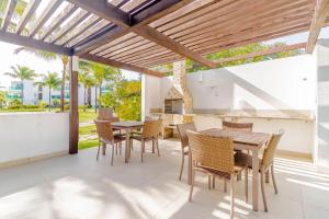 una sala da pranzo con tavolo e sedie su un patio di PF02 - Apt 3 Quartos - Condomínio Mediterrâneo Iberostate Praia do Forte a Praia do Forte