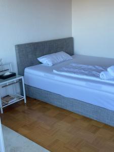 um quarto com uma cama e uma mesa de cabeceira ao lado em FlyHigh Apartment Stuttgart em Estugarda
