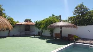 a villa with a swimming pool and a umbrella at Casa mono ambiente y piscina. in Limpio