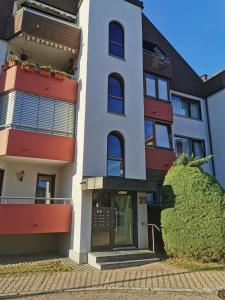 ein großes weißes Gebäude mit roten Akzenten in der Unterkunft Ferienwohnung Bad Säckingen ruhig und zentral in Bad Säckingen