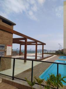 a building with a swimming pool next to a beach at Apartamento em Condomínio Frente Mar Barra Velha-SC in Barra Velha
