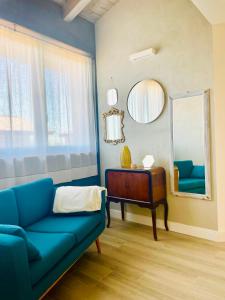 sala de estar con sofá azul y espejo en Locanda, en Gessate