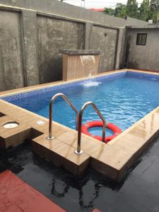 ラゴスにあるAlluring View Hotel - Allen Avenueの木製デッキ付きのプール、噴水付きのスイミングプール
