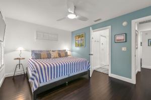 a bedroom with blue walls and a bed with a striped blanket at Weeden Cottage in St. Augustine