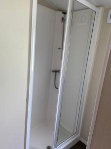 a shower stall with a mirror in a bathroom at Adams Caravan Holidays in Morecambe +6 photos