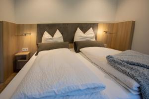 1 dormitorio con 2 camas con sábanas blancas y azules en Livin63 Studio Apartments en Hösbach