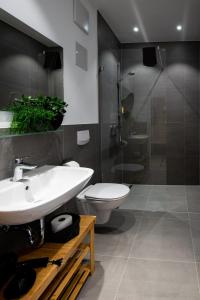 a bathroom with a toilet and a sink and a shower at Livin63 Studio Apartments in Hösbach