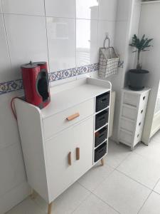 a white dresser with a red appliance on top of it at Apartamento Conchita in Vigo