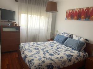a bedroom with a bed with a blue and white blanket at Apartamento Conchita in Vigo