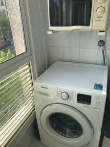 a washing machine with a microwave on top of it at Apartamento Conchita in Vigo