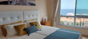 a bedroom with a large bed with a large window at Ocean view apartment in Golf del Sur in San Miguel de Abona
