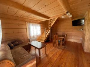 a living room with a couch and a table in a cabin at Domek u Orszulaków in Witów