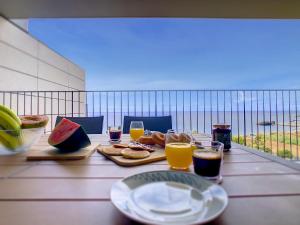 ein Tisch mit Tellern voller Essen und Gläsern mit Orangensaft in der Unterkunft The Best Sea View Apartment by LovelyStay in Funchal