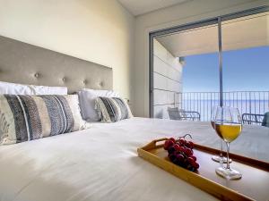 Bett mit einem Tablett mit Trauben und einem Glas Wein in der Unterkunft The Best Sea View Apartment by LovelyStay in Funchal
