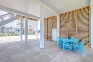 a dining room with a blue table and blue chairs at Summer Getaway Specials! Front Row Views - Tiki Bar - Playground - Fenced Yard in Bolivar Peninsula