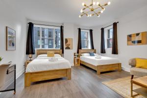 een slaapkamer met 2 bedden en een bank bij Le Sand & Stone Hotel in Montreal