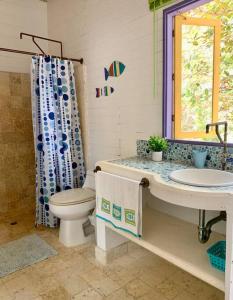 baño con lavabo y aseo y ventana en Casita Caribe en reserva natural, playa privada, kayaks, wifi, aire acondicionado, en San Onofre