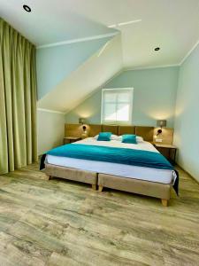 ein Schlafzimmer mit einem großen Bett mit blauer Bettwäsche in der Unterkunft Pokoje gościnne - Kasztelańska 8 in Stara Kamienica