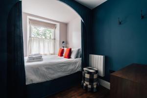 Schlafzimmer mit einem Bett, einem Fenster und einem Spiegel in der Unterkunft Redland Suites - Apartment 2 in Bristol