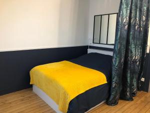um quarto com uma cama com um cobertor amarelo em L'Appart'Mans, luxueux, spacieux, bien situé em Le Mans