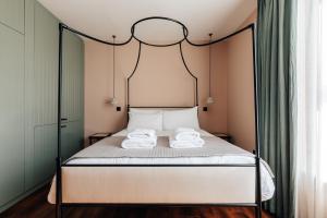 Redland Suites - Apartment 5 في بريستول: غرفة نوم مع سرير بأربعة أعمدة مع منشفتين