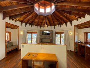 uma cozinha com uma mesa e um tecto com vigas de madeira em Atiaia Jungle River Retreat em Visconde de Mauá
