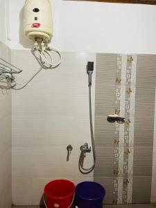 baño con ducha con 2 cubos y luz en NEST Mdy, en Mananthavady