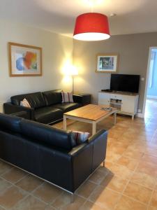 ein Wohnzimmer mit einem Sofa und einem Tisch in der Unterkunft Gites de Cognac in Bréville