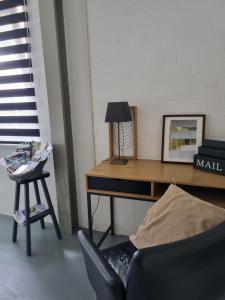 a desk with a lamp and a chair in a room at Vakantiewoning Schouwenberg in Swalmen