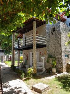 a small house with a porch and a balcony at Village Galés Maragogi in Maragogi