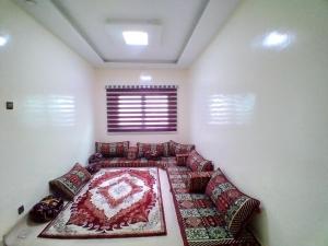 Una habitación con un sofá con una alfombra. en النسيم Nessim, en Nouakchott