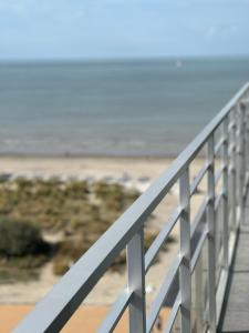 una barandilla blanca en un paseo marítimo cerca de la playa en Sunbeach en Nieuwpoort