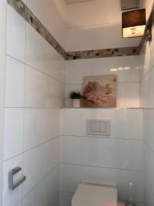 Sunbeach في نيوبورت: حمام مع مرحاض و لوحة على الحائط
