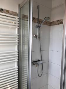 W łazience z przeszklonymi drzwiami znajduje się prysznic. w obiekcie Sunbeach w mieście Nieuwpoort