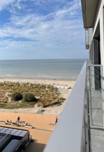 Blick auf den Strand vom Balkon eines Gebäudes in der Unterkunft Sunbeach in Nieuwpoort
