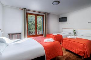 a hotel room with two beds and a window at Hôtel Saint Clair in Lourdes +46 photos