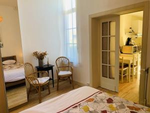 a bedroom with a bed and a table and chairs at Gîte: À la courbe du fleuve in Godinne