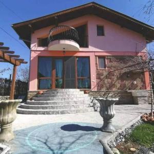 une maison rose avec des escaliers devant elle dans l'établissement River Hills Guest House, à Lesichevo