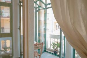 a balcony with glass doors and a wooden bench at Maga Mirò - Guest House in Salerno