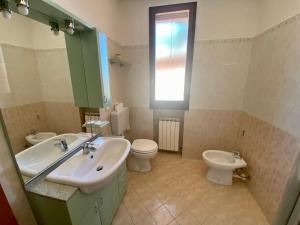 baño con lavabo y aseo y ventana en Appartamento la Pioppa con posto auto e Wi-Fi en Castelfranco Emilia