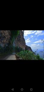 a picture of a mountain with a picture of a road at Isabela House in Ponta do Sol