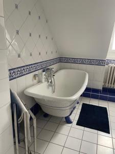 La salle de bains est pourvue d'une baignoire et d'un lavabo. dans l'établissement Le Char'Mans, cocon suréquipé en centre ville, au Mans