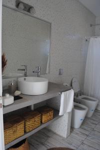 a bathroom with a sink and a toilet and a mirror at El Nido in Azcuénaga